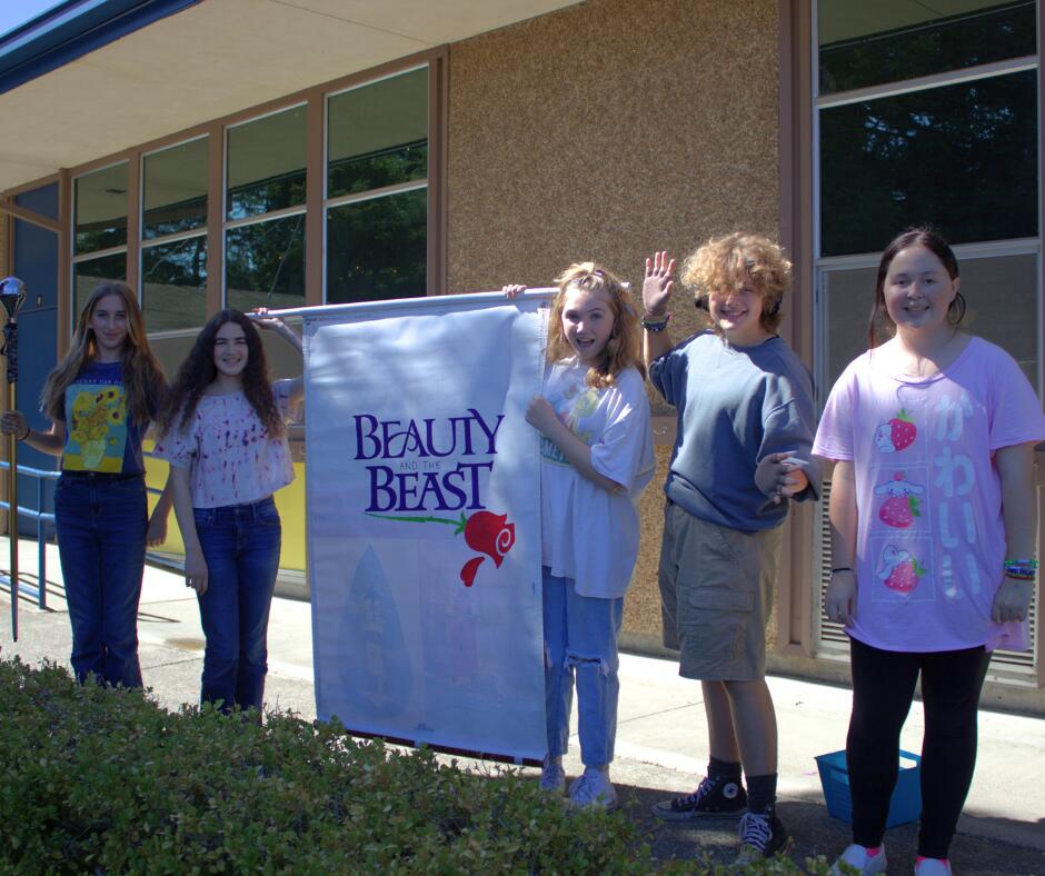 drama students holding a sign for beauty and the beast